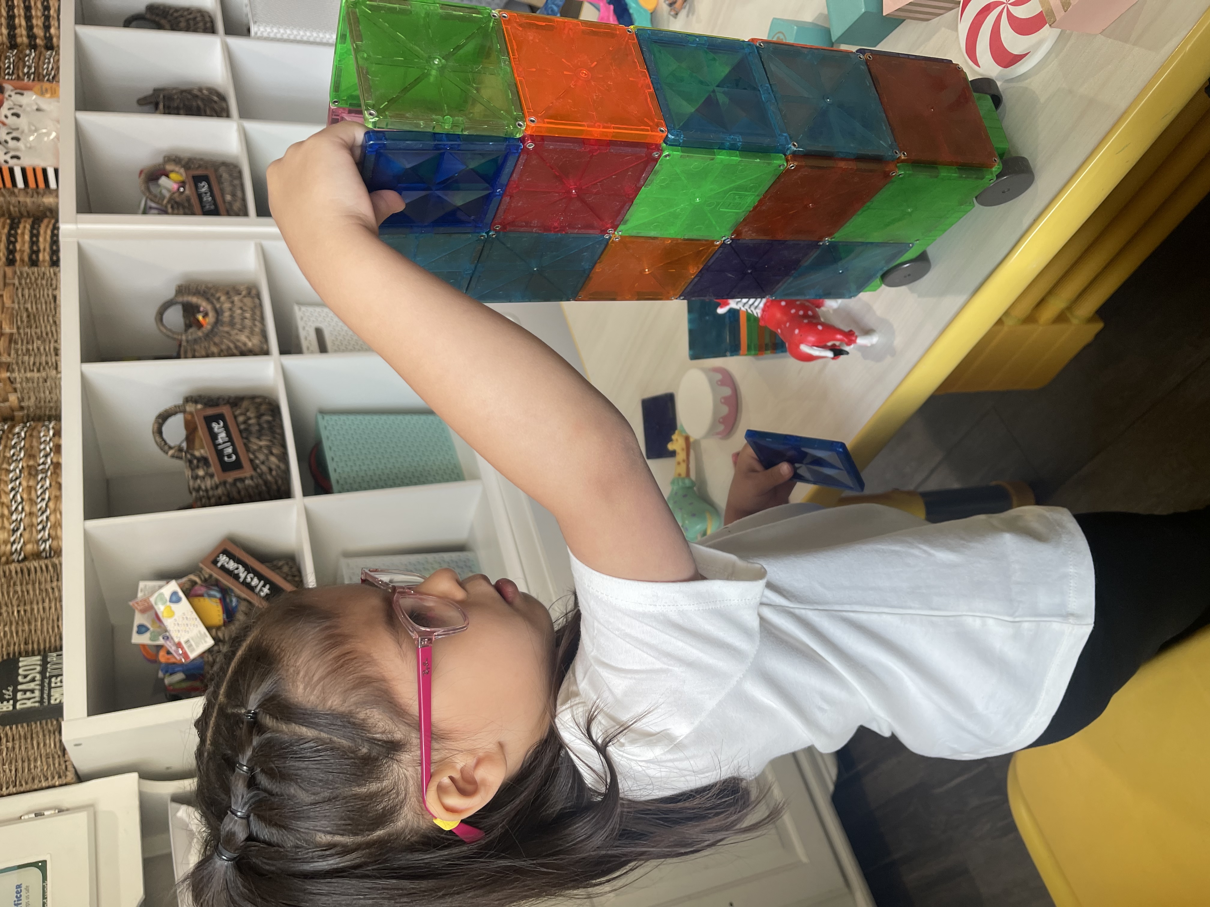Child building a tower with magnetic tiles