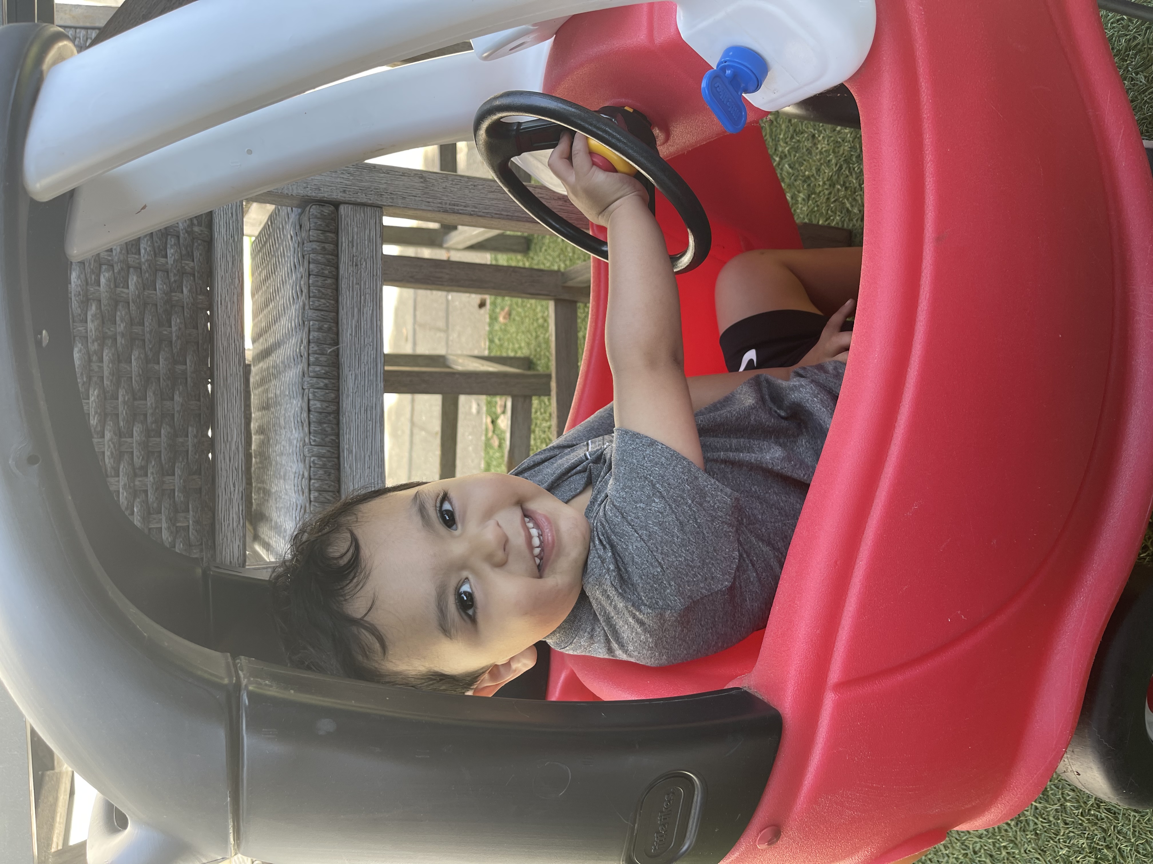Toddler smiling in a toy car